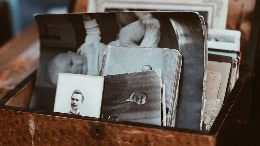 A wooden box filled with old family portraits, a fitting image for the patterns families hand down